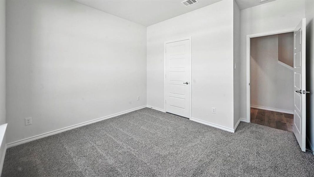 Unfurnished bedroom featuring dark carpet and a closet