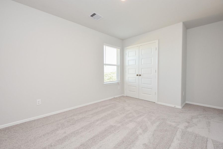 A corner window and ample closet make this carpeted secondary bedroom so appealing. A corner window and ample closet make this carpeted secondary bedroom so appealing.