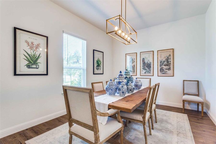 Dining space with hardwood / wood-style flooring and an inviting chandelier