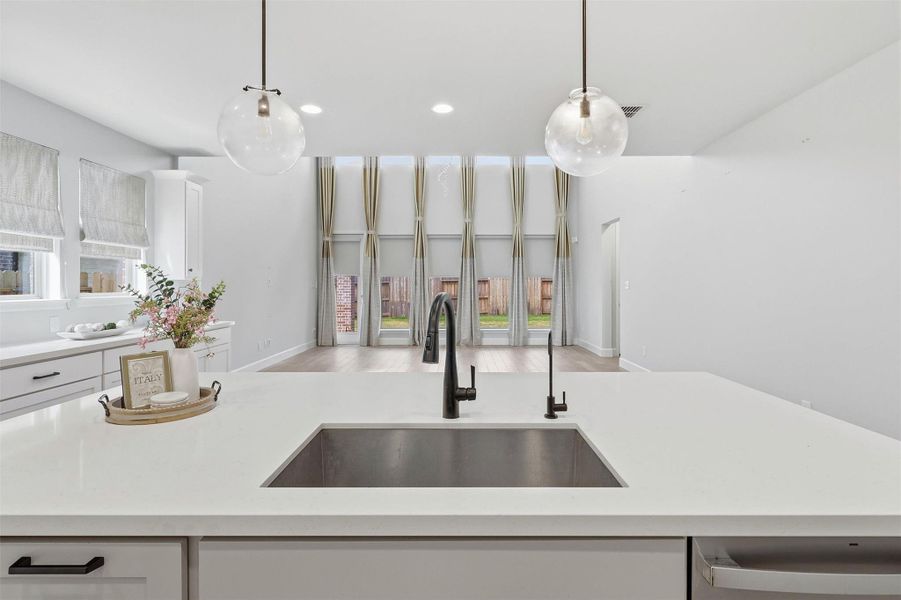 From the kitchen sink, enjoy uninterrupted views of the impressive two-story family room and backyard beyond. The oversized island creates the perfect gathering place while maintaining an open flow ideal for entertaining family and guests.