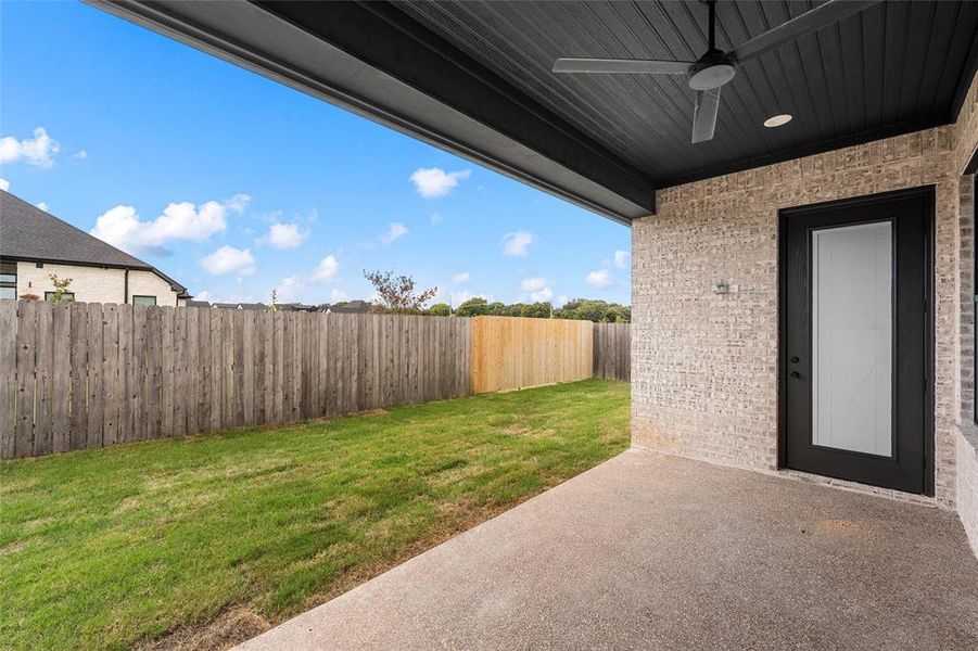Fenced backyard featuring a patio area and ceiling fan Fenced backyard featuring a patio area and ceiling fan