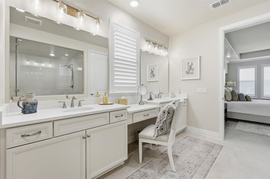 Full bath with a tile shower, double vanity, connected bathroom, light tile patterned floors, and recessed lighting