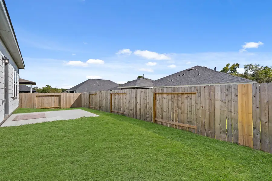 A fenced in yard with a house in the background. A fenced in yard with a house in the background.