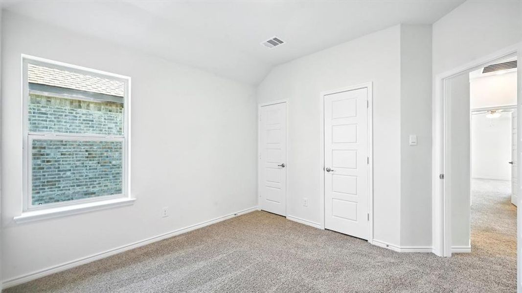 Unfurnished bedroom featuring carpet floors and lofted ceiling