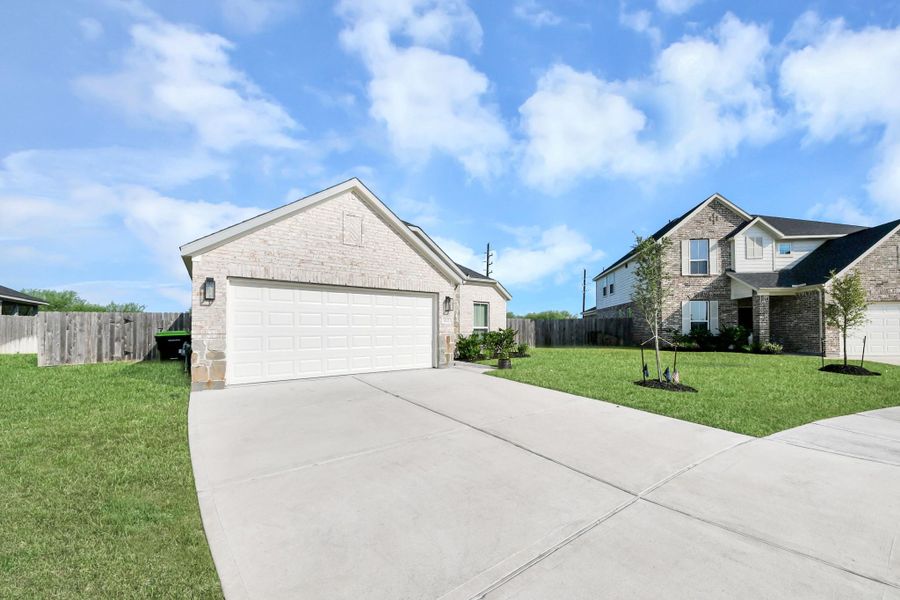 An immaculate concrete drive leads up to the attached two-car garage, offering seamless arrival and extra storage potential.