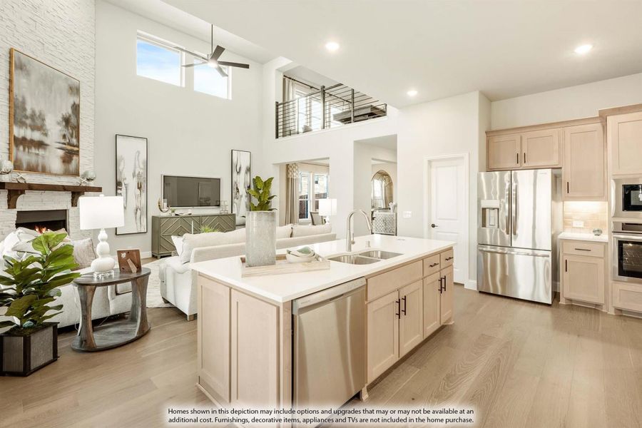 Open-concept kitchen with center island, stainless appliances, and two-story living room with fireplace and loft overlook