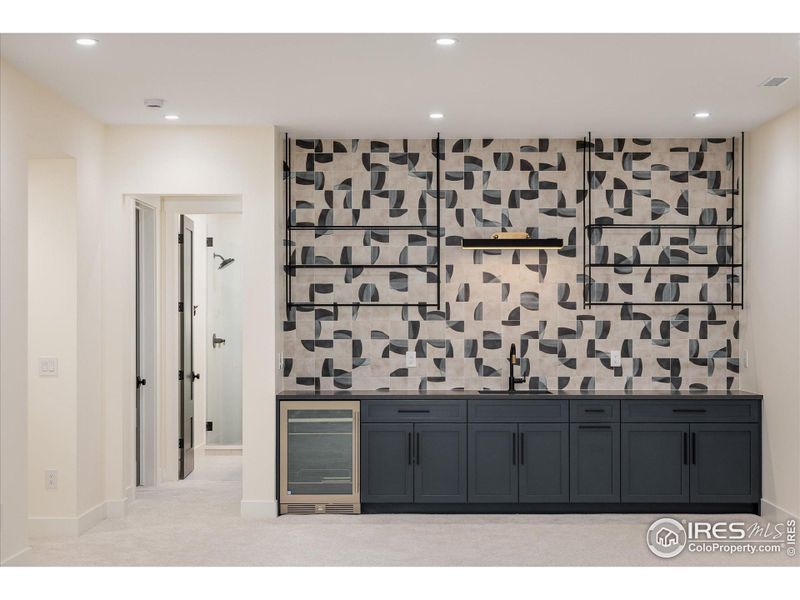 This is a one-of-a-kind custom tile backsplash, and it is a perfect backdrop for the wet bar in the Rec Room, complete with open shelving