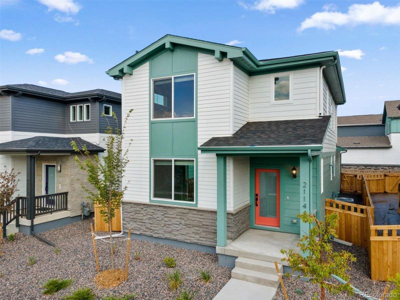Front exterior of a new home in Woodrose at Painted Prairie, Aurora, CO, highlighting curb appeal (Image 21).