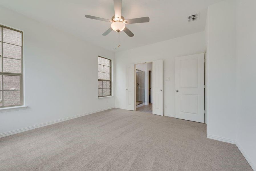 Unfurnished bedroom featuring carpet flooring and a ceiling fan Unfurnished bedroom featuring carpet flooring and a ceiling fan