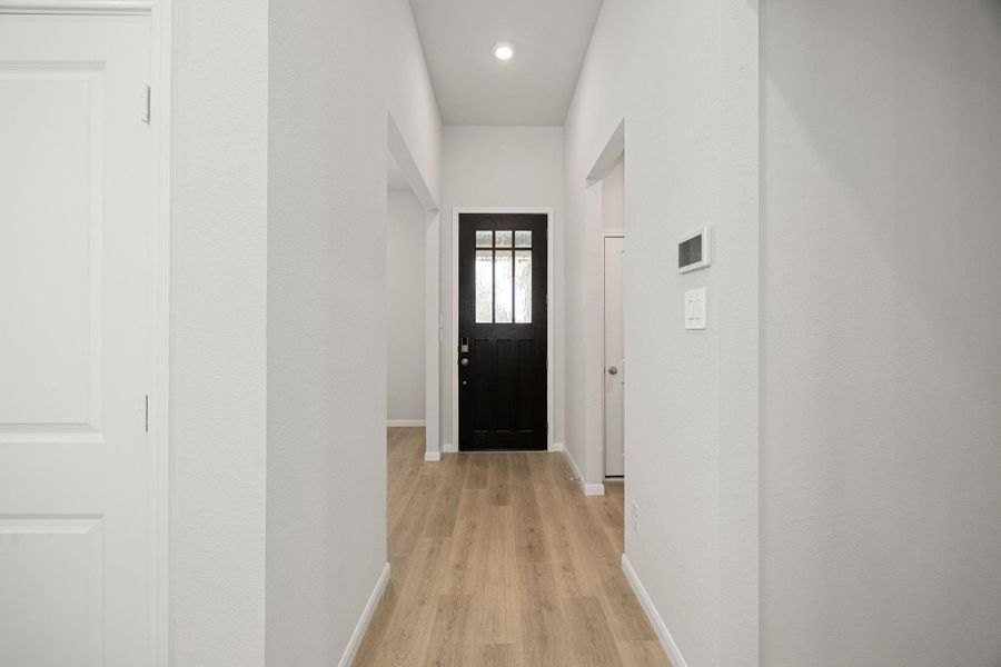 An inviting and bright entryway hall features durable, light-toned wood-look flooring and neutral wall colors. An inviting and bright entryway hall features durable, light-toned wood-look flooring and neutral wall colors.