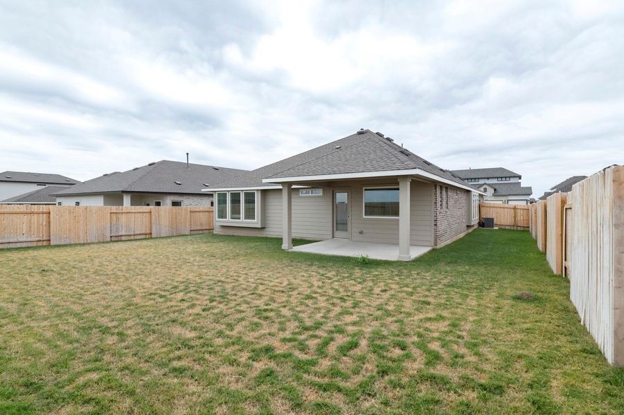 Back of property with a patio, a fenced backyard, and roof with shingles
