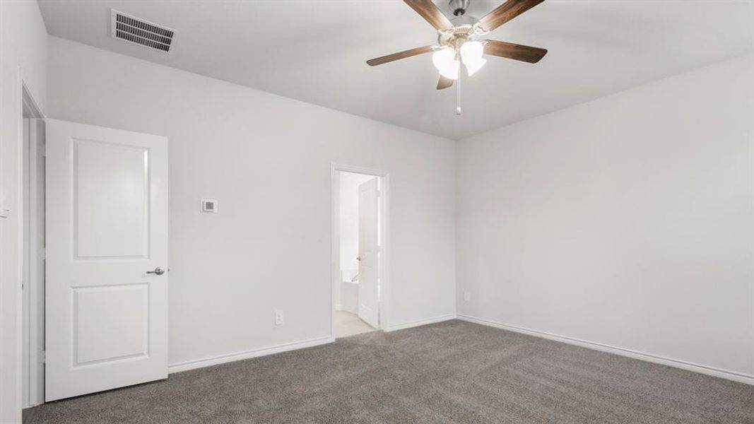 Spare room with dark colored carpet and a ceiling fan