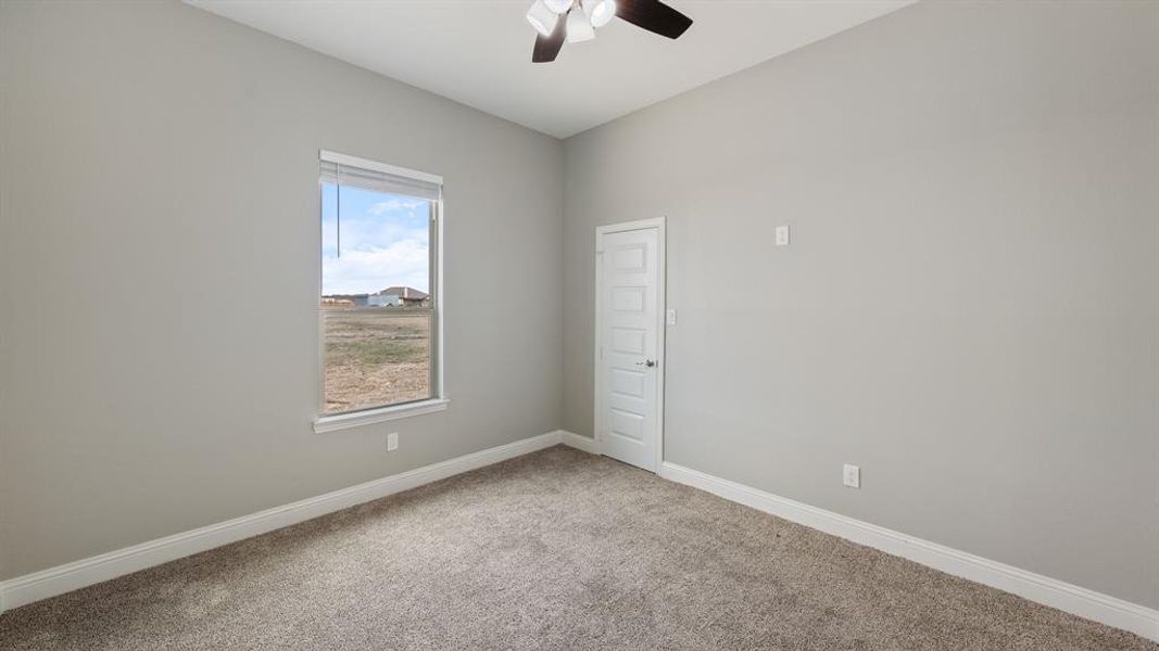 Spare room featuring carpet floors, baseboards, and a ceiling fan