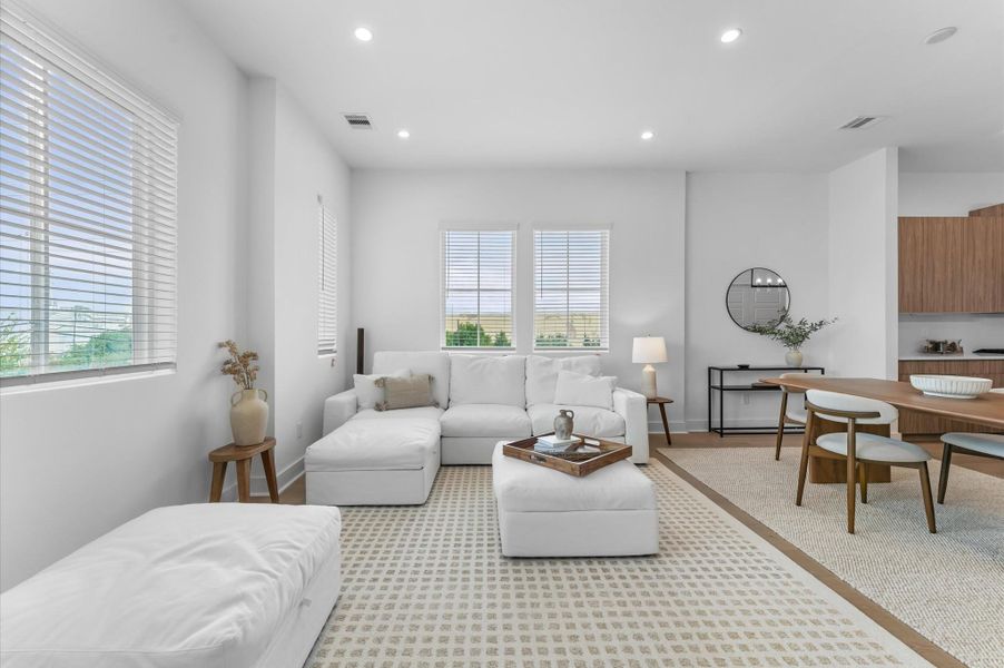 The second floor boasts a spacious open-concept living, dining, and kitchen area filled with natural light from abundant windows, featuring sleek modern finishes and warm engineered hardwood floors that create the perfect blend of style and comfort for everyday living and entertaining.