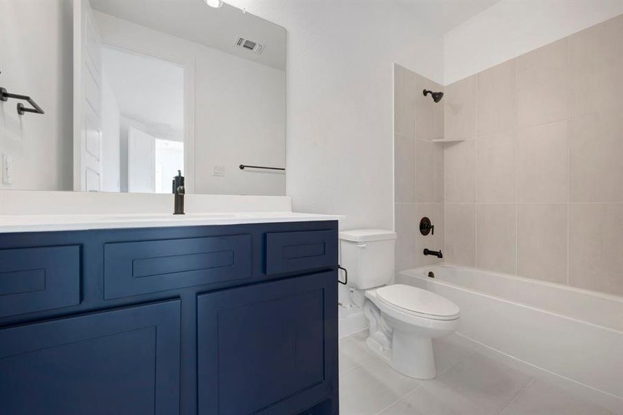 Bathroom featuring a navy blue vanity with a white countertop, a rectangular undermount sink, and a black faucet