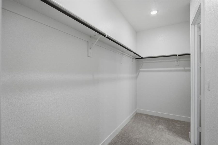 Walk in closet featuring light colored carpet