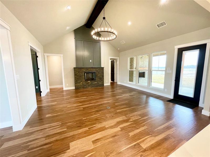 High vaulted beams ceiling, ledger stone fireplace and an impressive chandelier.