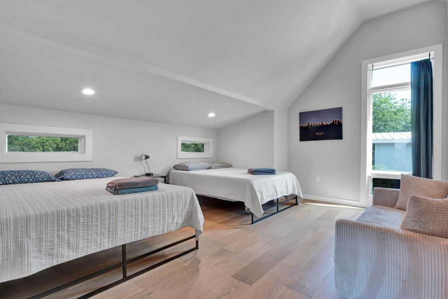 Bedroom featuring vaulted ceiling, light wood finished floors, and recessed lighting