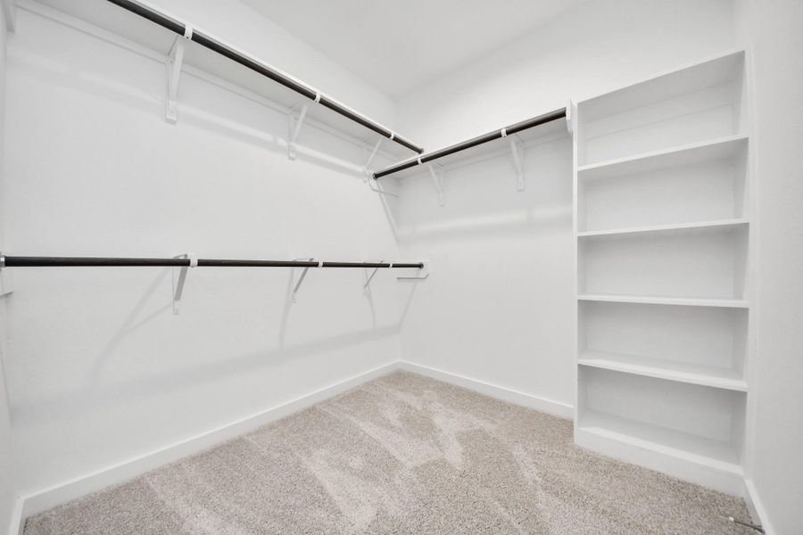 Walk-in closet that epitomizes luxury and practicality. This generously sized space features built-in shelving, offering abundant room for impeccable organization. High ceilings and recessed lighting create a bright and welcoming ambiance. Walk-in closet that epitomizes luxury and practicality. This generously sized space features built-in shelving, offering abundant room for impeccable organization. High ceilings and recessed lighting create a bright and welcoming ambiance.