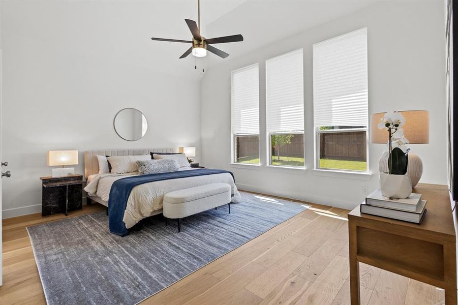 Bedroom featuring light wood-style floors, ceiling fan, and lofted ceiling