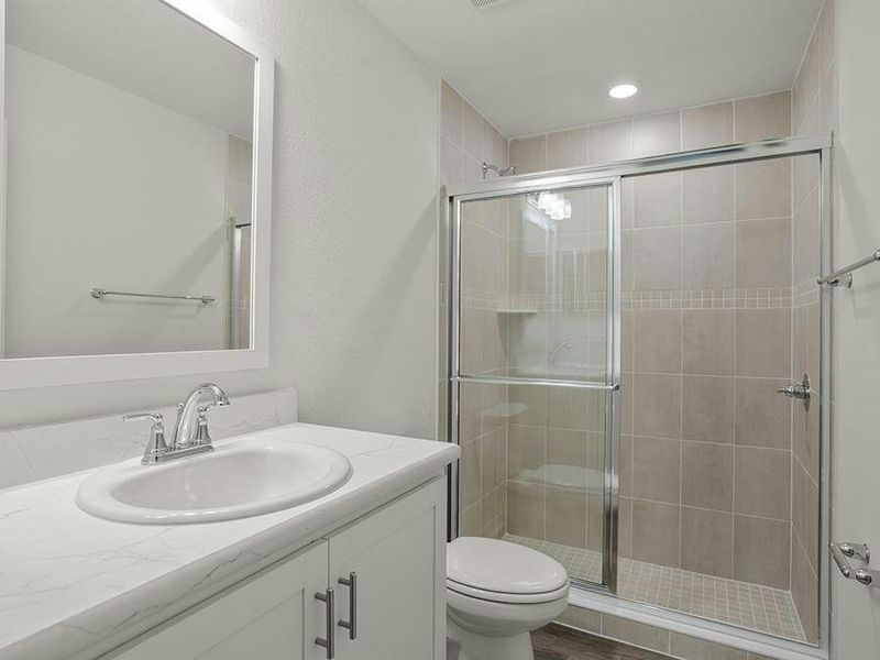 Your en-suite owner`s bath features a tiled, glass-enclosed shower.