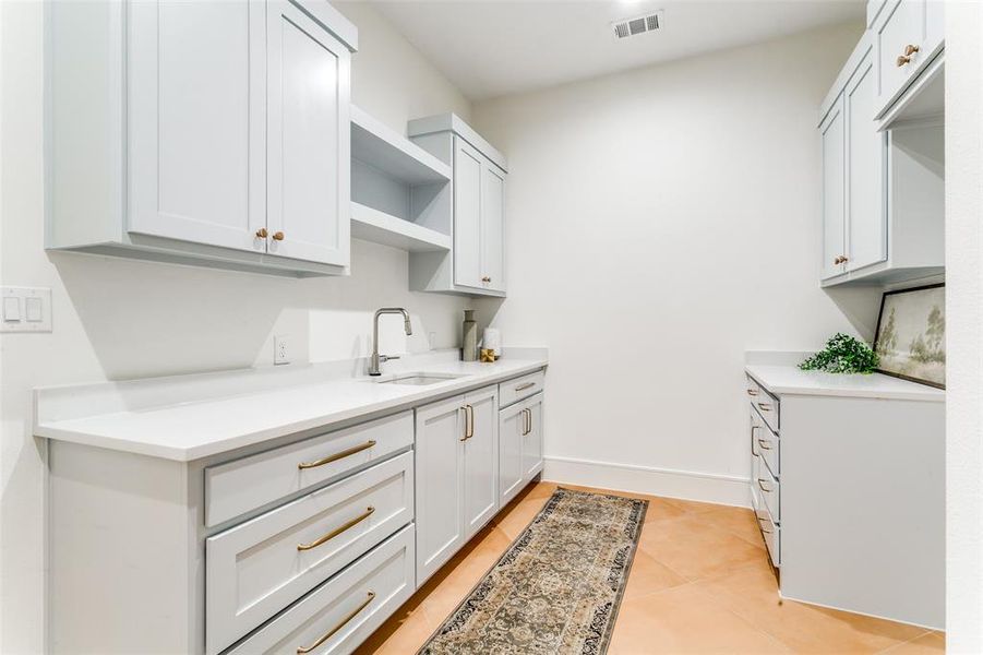 Laundry center is spacious with an abundance of storage, sink, hanging bar, and a full-sized washer and dryer connection. Laundry center is spacious with an abundance of storage, sink, hanging bar, and a full-sized washer and dryer connection.