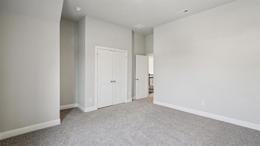 Unfurnished bedroom featuring light carpet and a closet Unfurnished bedroom featuring light carpet and a closet
