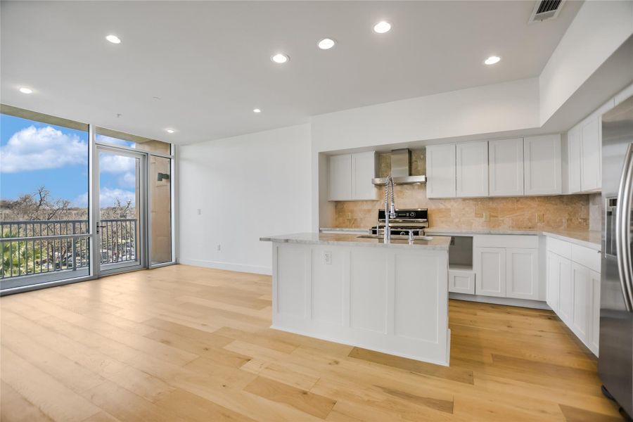 Dining, Kitchen & Living to East-facing Balcony with Downtown view, Sunrise & Pecan Grove Treeline