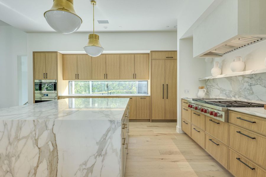 Culinary excellence awaits in this kitchen featuring an expansive marble island and custom oak cabinetry. Culinary excellence awaits in this kitchen featuring an expansive marble island and custom oak cabinetry.