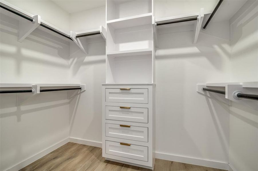 Spacious closet with light hardwood / wood-style floors