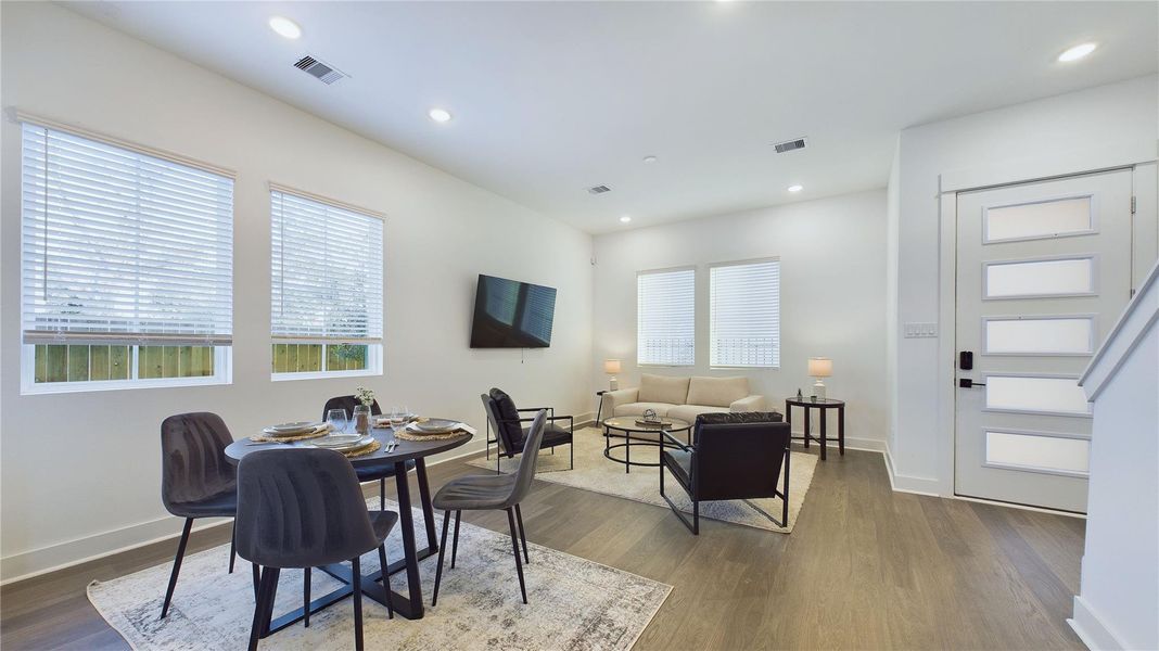 Designed for modern living, this open-concept space seamlessly unites the kitchen, dining, and living areas into one harmonious hub. The kitchen anchors the layout with a large center island, sleek cabinetry, and pendant lighting that adds a touch of sophistication. Just steps away, the dining area offers ample room for gatherings, while the spacious living room invites relaxation with abundant natural light and flexible seating.