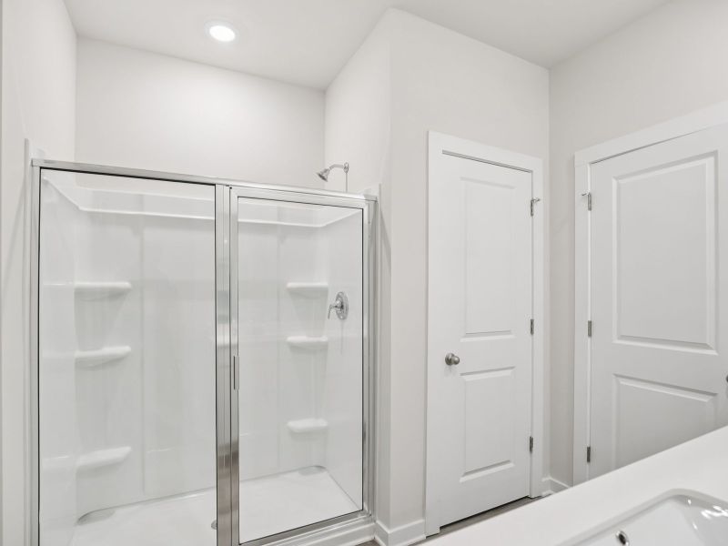 The primary bathroom offers dual vanity sinks and a walk-in shower.