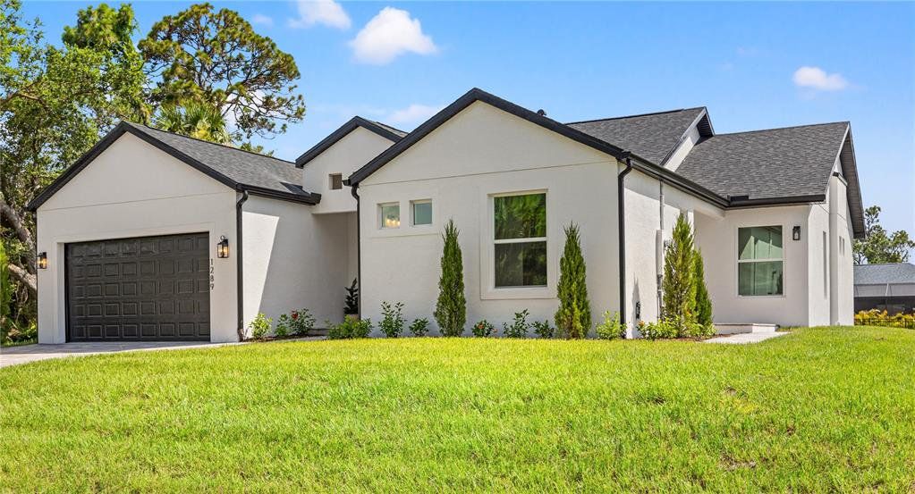 Front exterior of a new home in , North Port, FL, highlighting curb appeal (Image 1). Front exterior of a new home in , North Port, FL, highlighting curb appeal (Image 1).