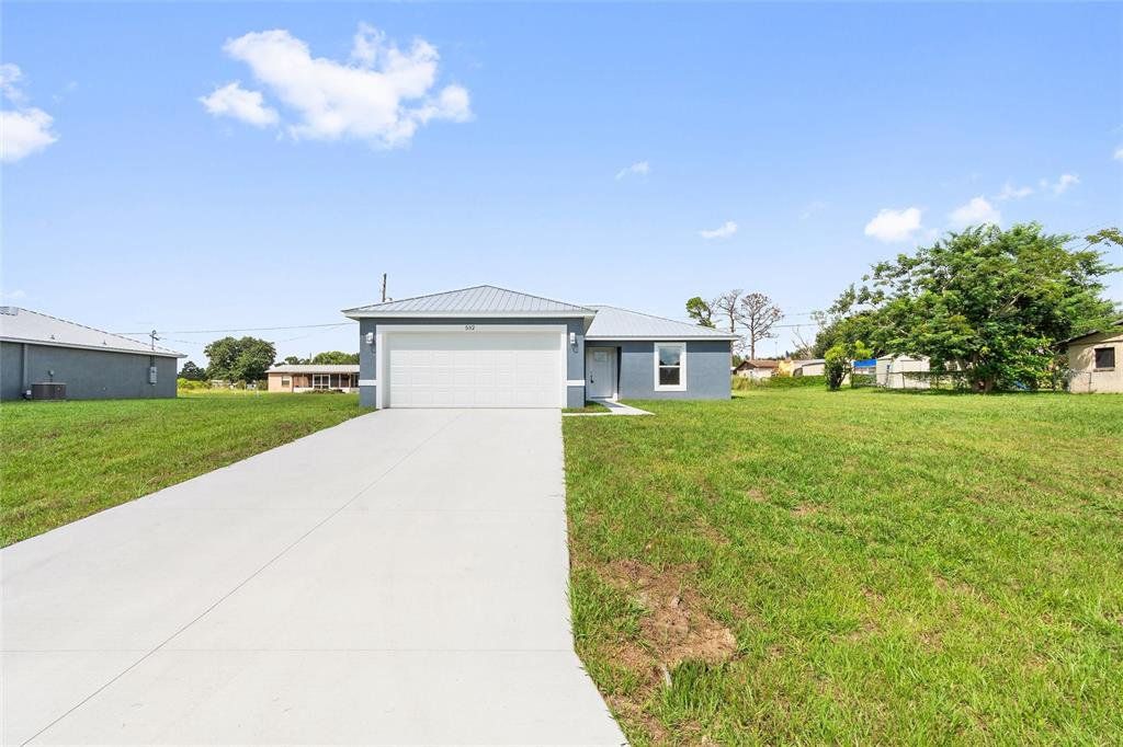 Front exterior of a new home in , Frostproof, FL, highlighting curb appeal (Image 1).