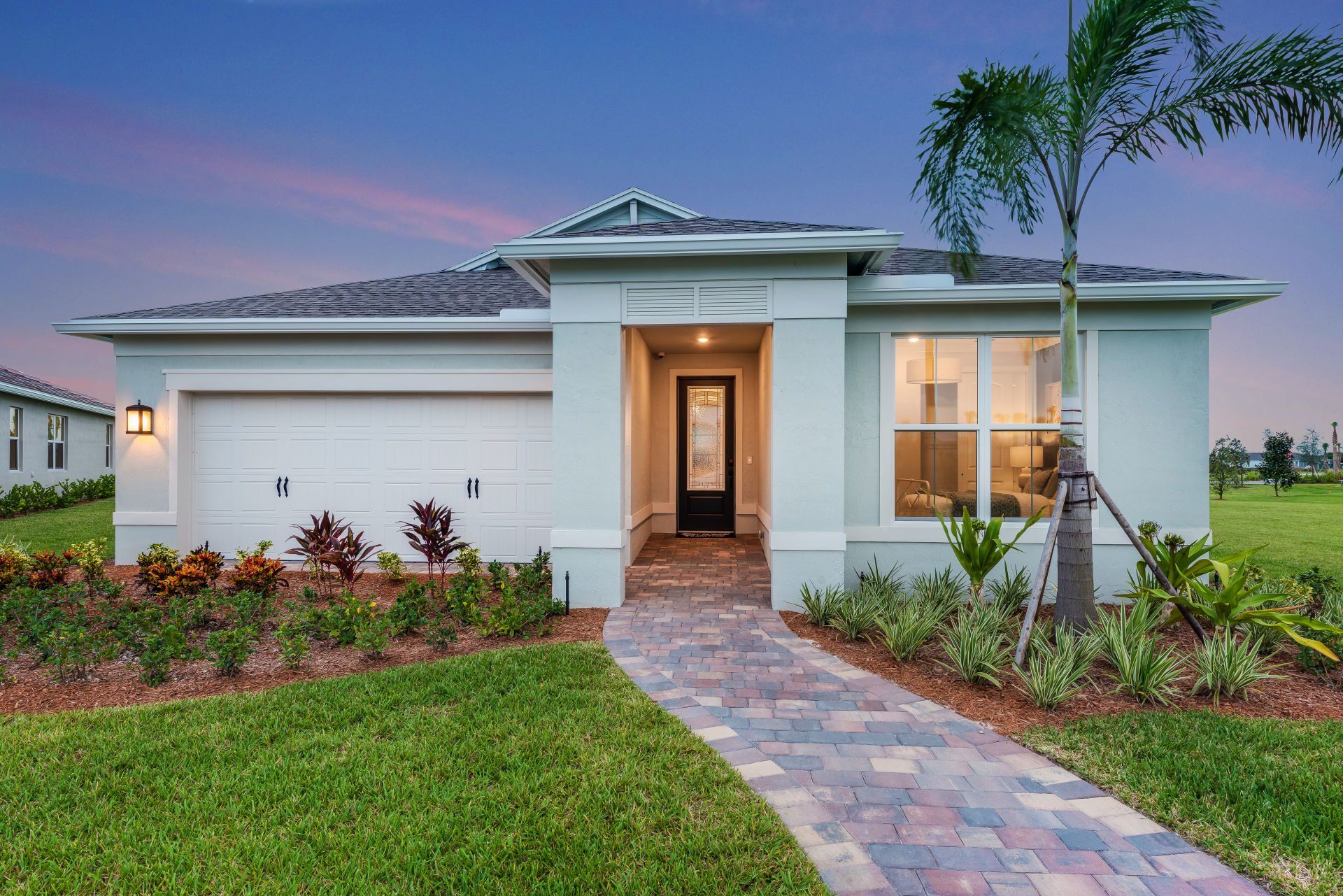 Front exterior of a new home in Del Webb Tradition, Port St. Lucie, FL, highlighting curb appeal (Image 1).