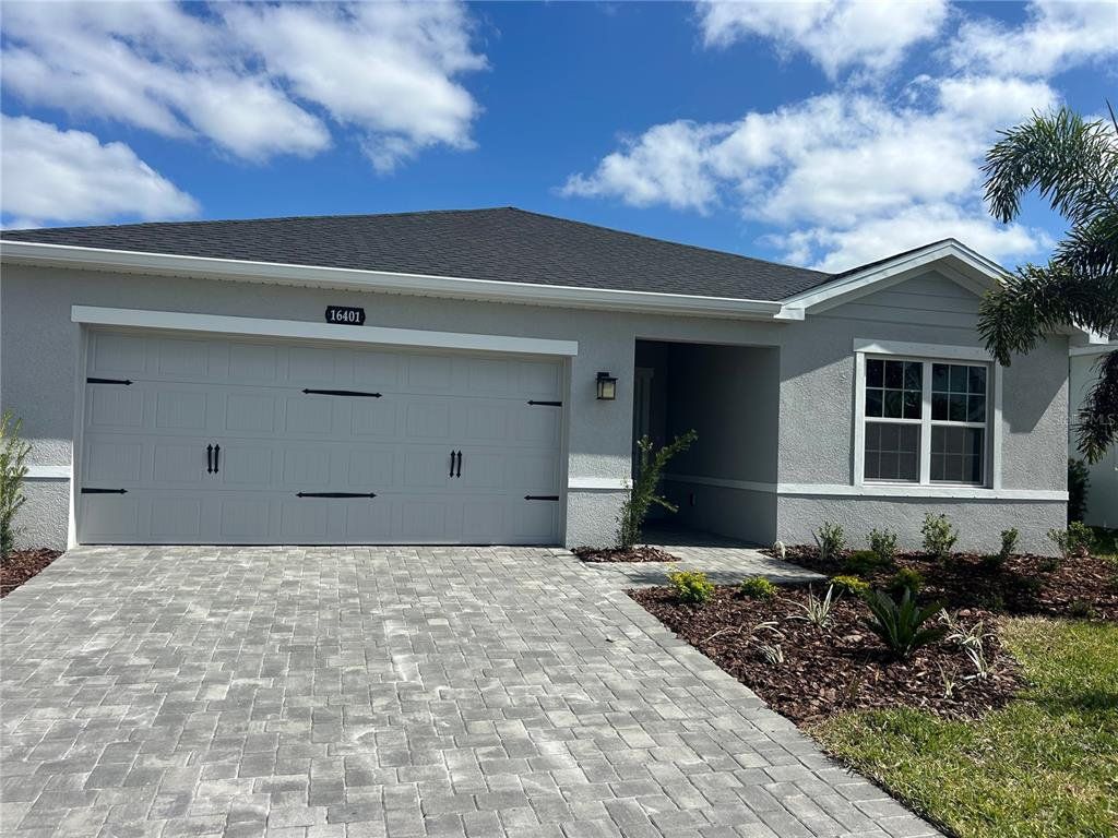 Front exterior of a new home in West Port Single Family Homes, Port Charlotte, FL, highlighting curb appeal (Image 1). Front exterior of a new home in West Port Single Family Homes, Port Charlotte, FL, highlighting curb appeal (Image 1).