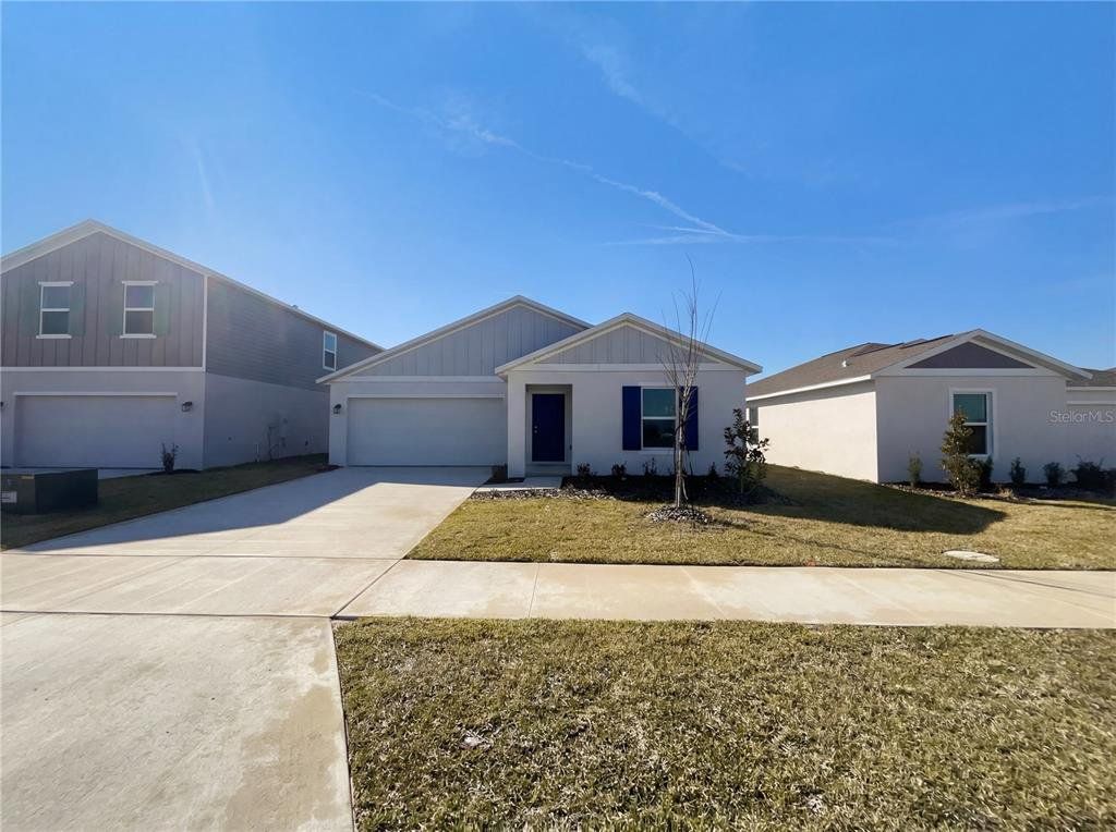 Front exterior of a new home in Peace Creek Reserve, Winter Haven, FL, highlighting curb appeal (Image 1). Front exterior of a new home in Peace Creek Reserve, Winter Haven, FL, highlighting curb appeal (Image 1).