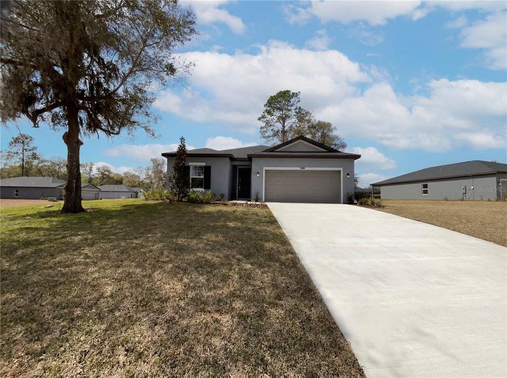 Front exterior of a new home in Grand Park, Dunnellon, FL, highlighting curb appeal (Image 1). Front exterior of a new home in Grand Park, Dunnellon, FL, highlighting curb appeal (Image 1).