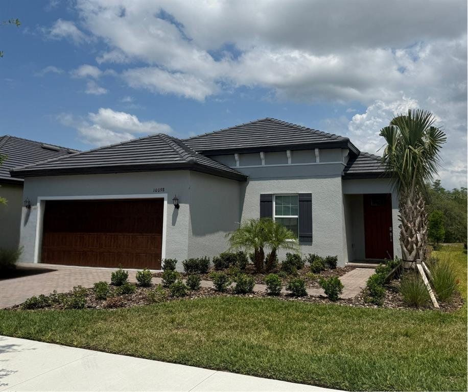 Front exterior of a new home in Angeline Active Adult: Active Adult Manors, Land O' Lakes, FL, highlighting curb appeal (Image 1). Front exterior of a new home in Angeline Active Adult: Active Adult Manors, Land O' Lakes, FL, highlighting curb appeal (Image 1).
