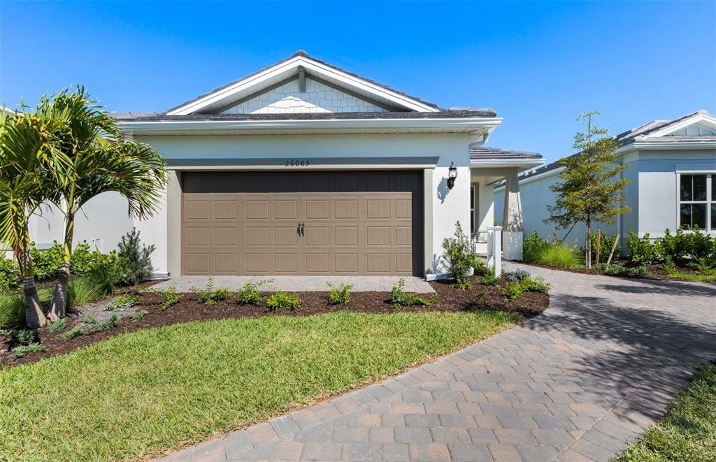 Front exterior of a new home in BeachWalk by Manasota Key, Englewood, FL, highlighting curb appeal (Image 1). Front exterior of a new home in BeachWalk by Manasota Key, Englewood, FL, highlighting curb appeal (Image 1).