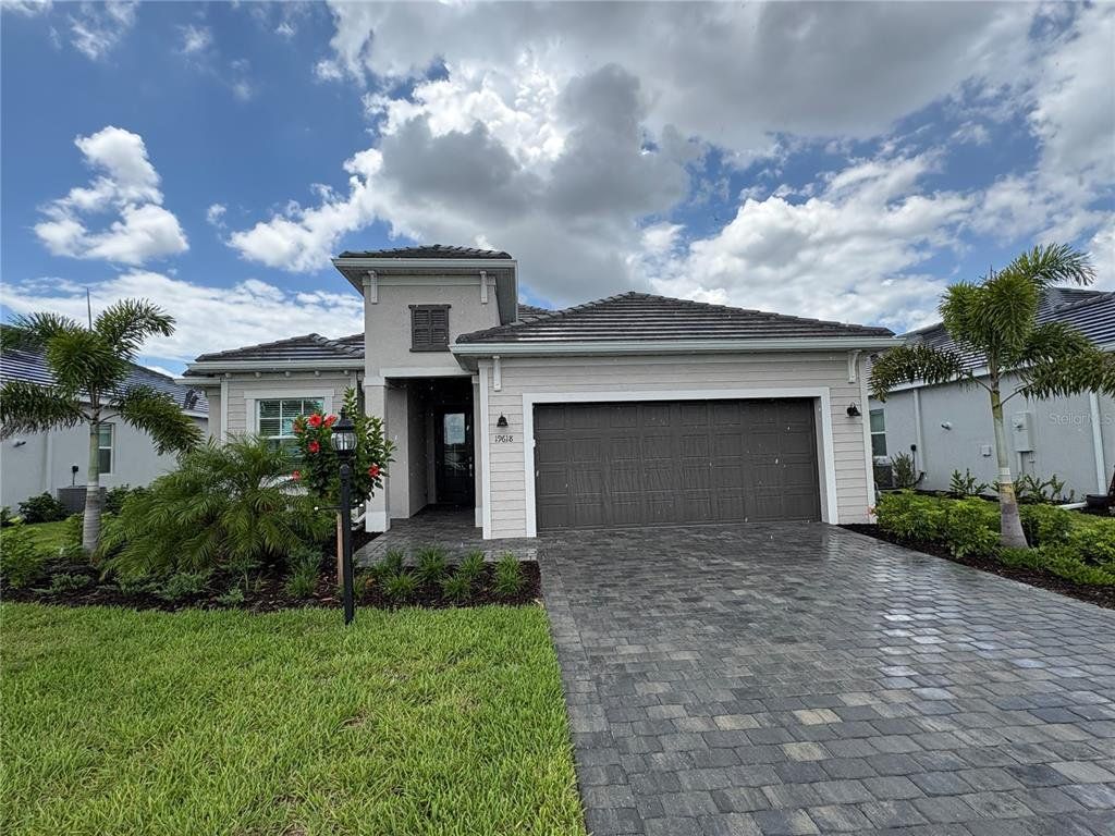 Front exterior of a new home in Calusa Country Club, Lakewood Ranch, FL, highlighting curb appeal (Image 1). Front exterior of a new home in Calusa Country Club, Lakewood Ranch, FL, highlighting curb appeal (Image 1).