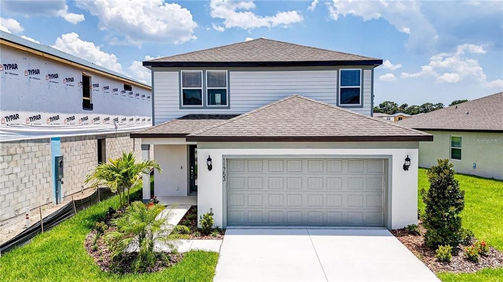 Front exterior of a new home in Isles at BayView, Parrish, FL, highlighting curb appeal (Image 1). Front exterior of a new home in Isles at BayView, Parrish, FL, highlighting curb appeal (Image 1).