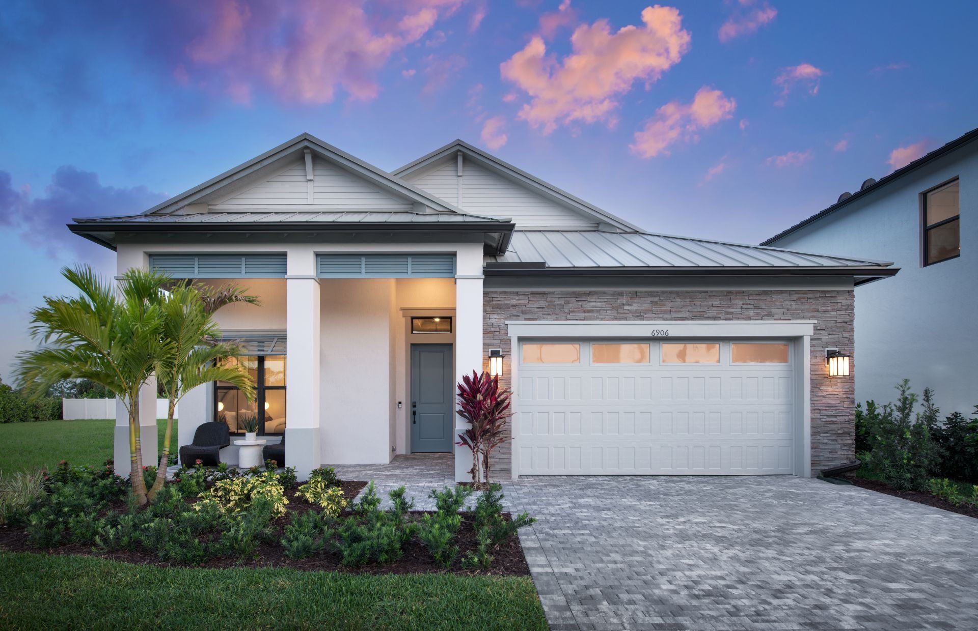 Front exterior of a new home in The Reserve at Eastpointe, Palm Beach Gardens, FL, highlighting curb appeal (Image 1).