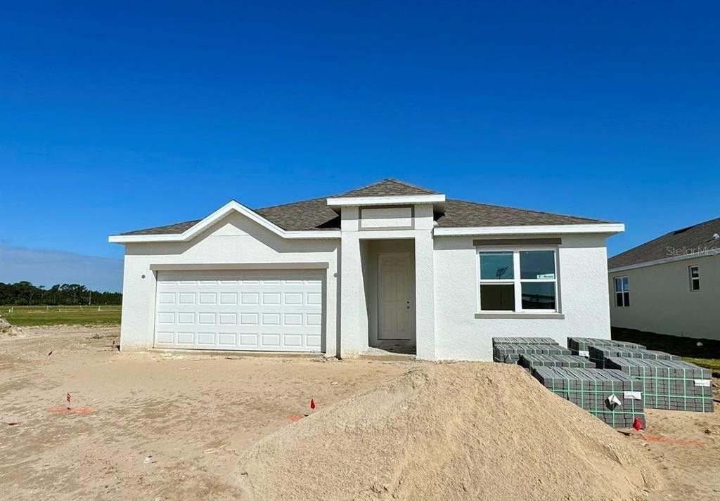 Front exterior of a new home in Highfield at Twisted Oaks, Wildwood, FL, highlighting curb appeal (Image 1). Front exterior of a new home in Highfield at Twisted Oaks, Wildwood, FL, highlighting curb appeal (Image 1).