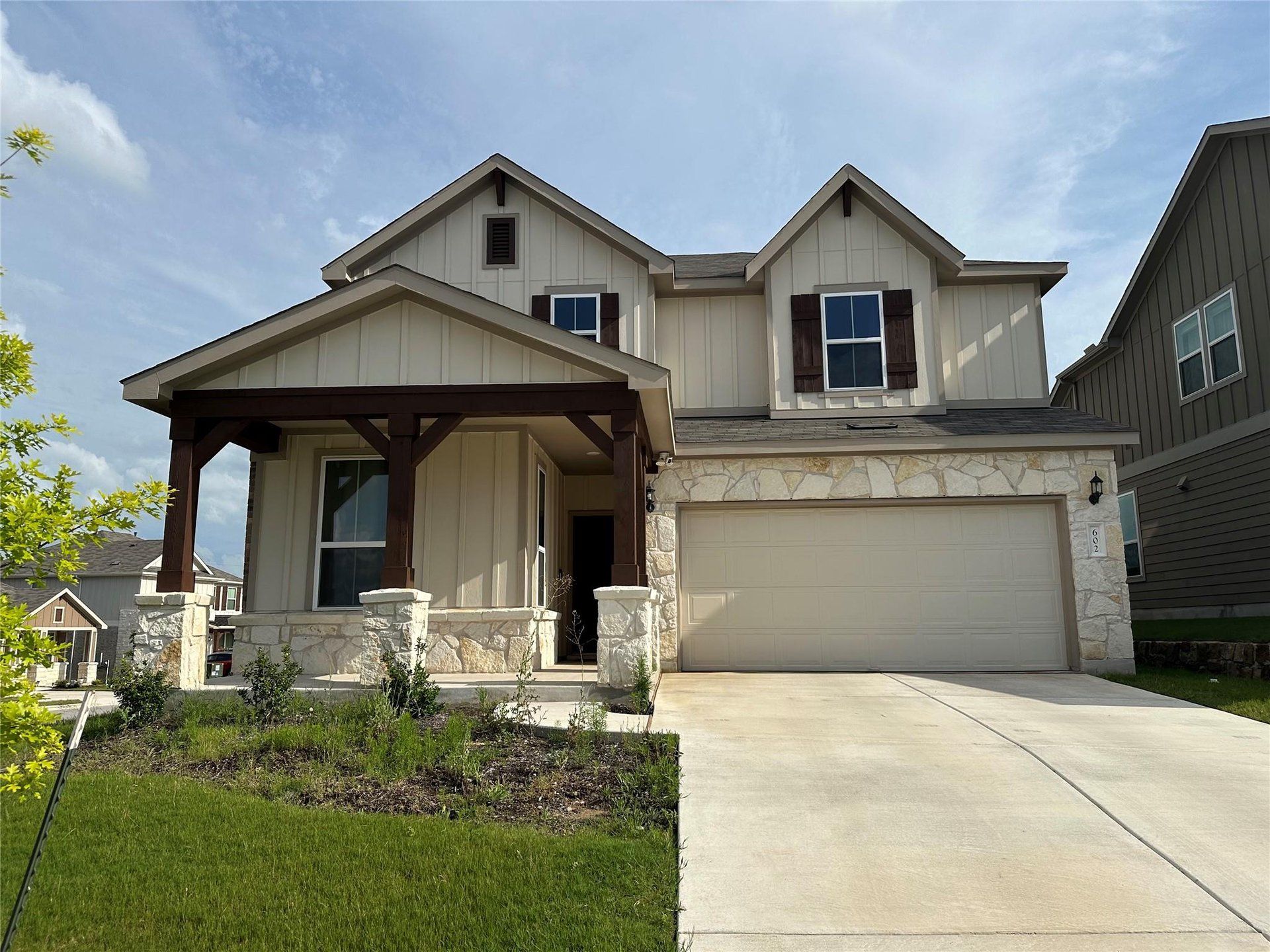 Crafted with board and batten siding and stone accents, this charming home features a welcoming covered entry. Crafted with board and batten siding and stone accents, this charming home features a welcoming covered entry.