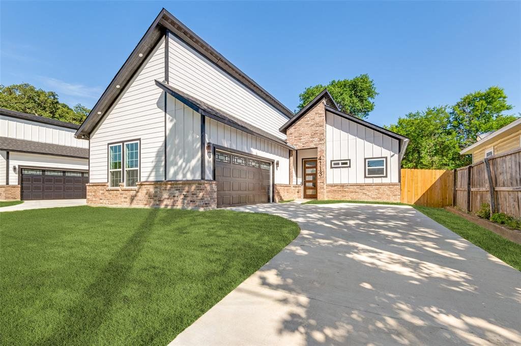 View of front facade with board and batten siding, brick siding, a garage, and concrete driveway View of front facade with board and batten siding, brick siding, a garage, and concrete driveway