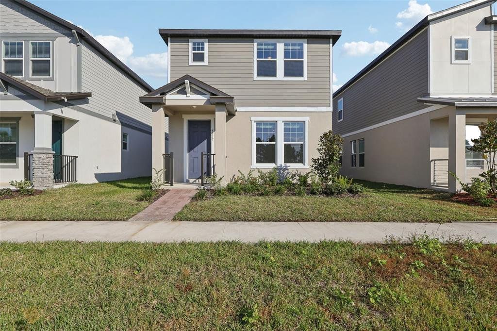 Front exterior of a new home in The Meadow at Crossprairie Bungalows, St. Cloud, FL, highlighting curb appeal (Image 1). Front exterior of a new home in The Meadow at Crossprairie Bungalows, St. Cloud, FL, highlighting curb appeal (Image 1).