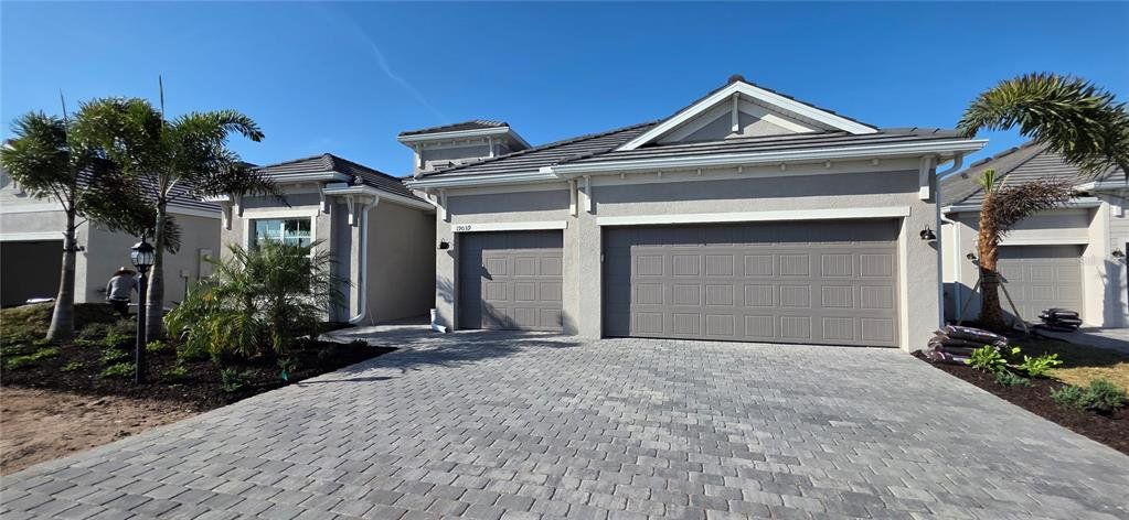 Front exterior of a new home in Calusa Country Club, Lakewood Ranch, FL, highlighting curb appeal (Image 1). Front exterior of a new home in Calusa Country Club, Lakewood Ranch, FL, highlighting curb appeal (Image 1).