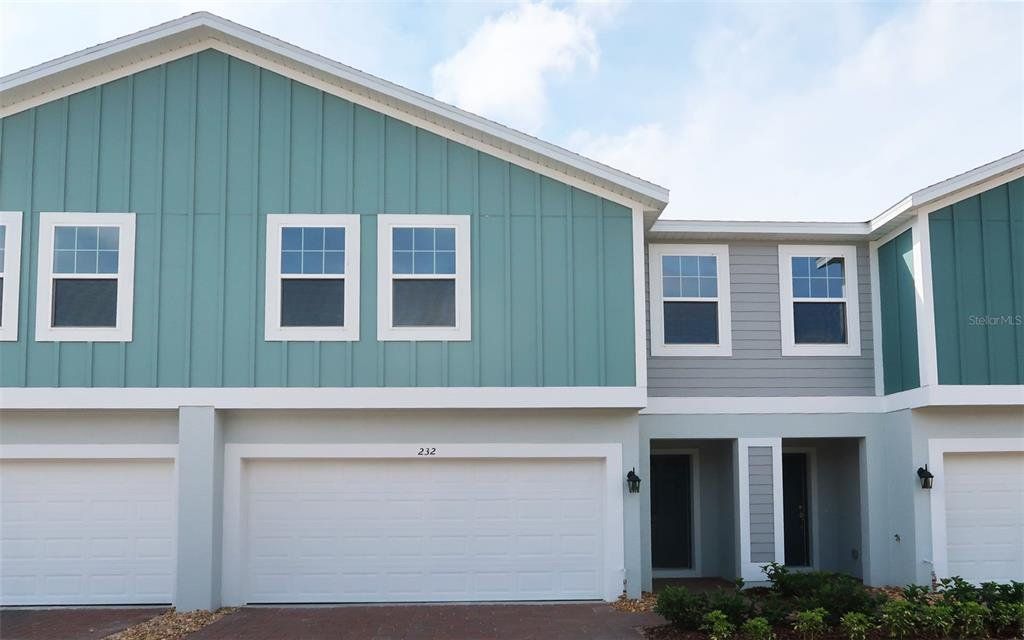 Front exterior of a new home in Blue Springs Reserve Townhomes, Groveland, FL, highlighting curb appeal (Image 1). Front exterior of a new home in Blue Springs Reserve Townhomes, Groveland, FL, highlighting curb appeal (Image 1).