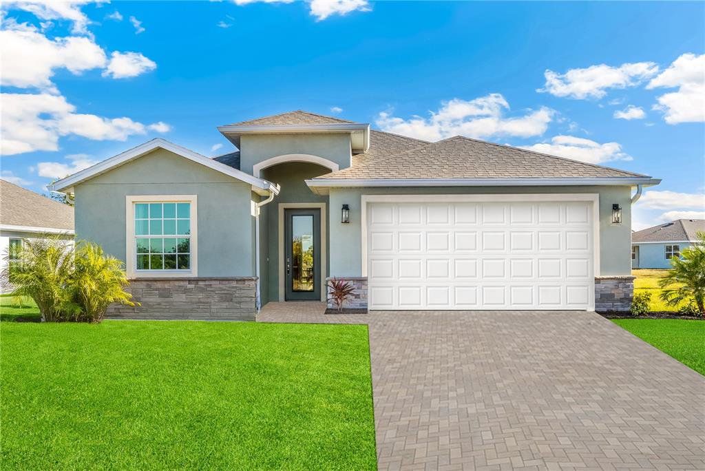 Front exterior of a new home in Coral Lakes - Tradition & Express, Punta Gorda, FL, highlighting curb appeal (Image 1). Front exterior of a new home in Coral Lakes - Tradition & Express, Punta Gorda, FL, highlighting curb appeal (Image 1).
